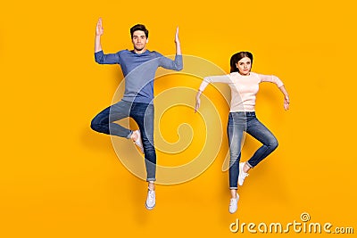 Full length photo of serious team married couple jump raise hands dance like humanoid robots wear stylish modern clothes Stock Photo