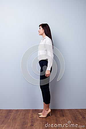 Full-length photo of side view of young confident businesswoman on gray background Stock Photo