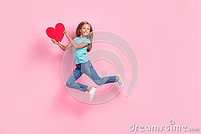 Full length photo of sweet adorable small kid wear turquoise t-shirt holding red heart jumping high pink color Stock Photo