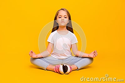 Full length photo of sweet charming school girl wear white t-shirt enjoying yoga sitting floor isolated yellow color Stock Photo