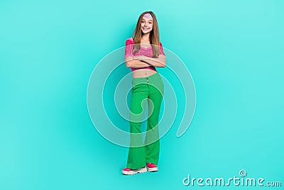 Full length photo of sweet pretty schoolgirl wear pink crop top flared pants arms crossed isolated turquoise color Stock Photo