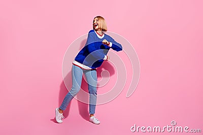 Full length photo young carefree girl meloman loves dancing boogie woogie funky moves looking empty space isolated on Stock Photo
