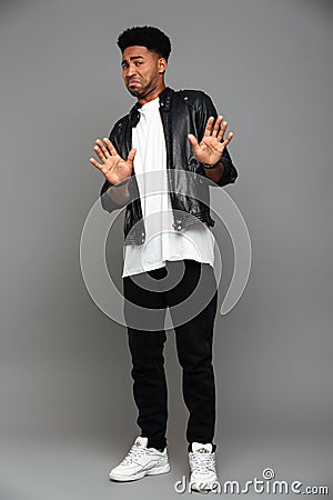 Full length photo of young displeased african guy swoving stop g Stock Photo