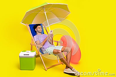 Full length photo of young guy lying sunbed wear shorts read new smartphone messages social media blog isolated on Stock Photo