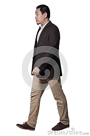 Full length portrait of Asian businessman wearing brown suit standing walking, side view profile Stock Photo