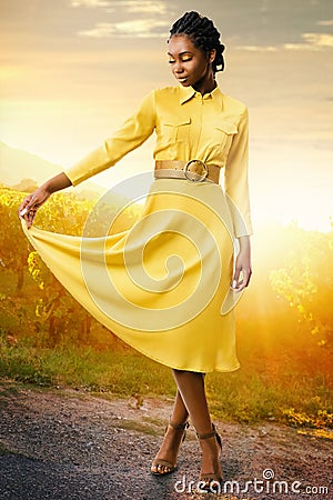 Attractive black girl wearing stylish yellow dress in vineyard. Stock Photo
