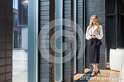 Full length portrait of attractive successful businesswoman with long blond hair in office style clothes Stock Photo