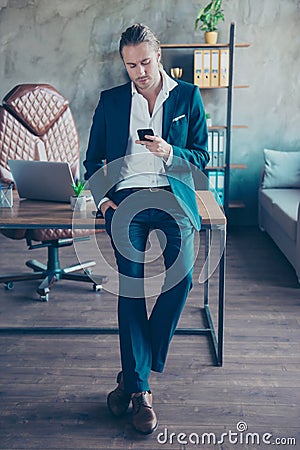Full length portrait of busy rich director leaning on table i Stock Photo