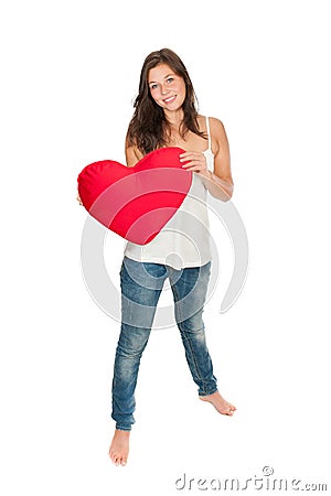 Full length portrait of a gorgeous smiling woman holding a red heart pillow Stock Photo