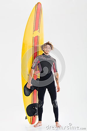 Full length portrait of a happy surfer holding surf board Stock Photo