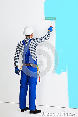 Full length portrait of rear view of painter man painting the wa Stock Photo