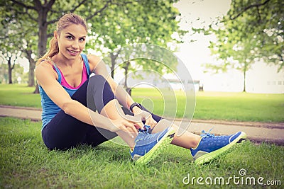 Full length portrait of smiling woman tying shoelace Stock Photo