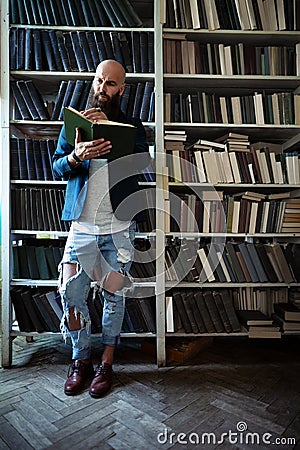 Full length portrait of stylish bearded man reading book Stock Photo