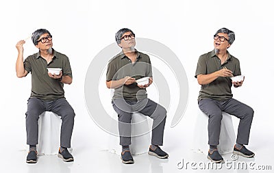 Full length 50s 60s Asian Chinese shop owner man, eating food chopstick bowl Stock Photo