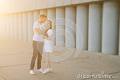 Full length shot portrait of romantic young couple in love embracing while man touching neck of girlfriends with hand. Stock Photo