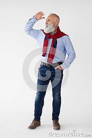 Smiling senior bearded man looking sideway, holding hands near f Stock Photo