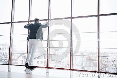 Full length shot of a stylish young businessman wearing a modern suit, who is a high achiever, standing on the top floor Stock Photo