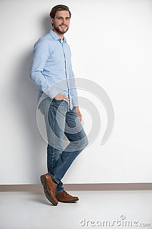 Full length studio portrait of casual young man in jeans and shirt. Isolated on white background. Stock Photo