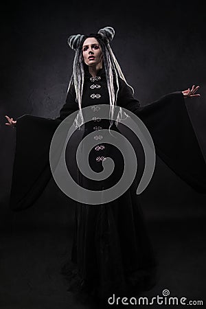 Full length view of woman with dreads wearing black gothic coat Stock Photo