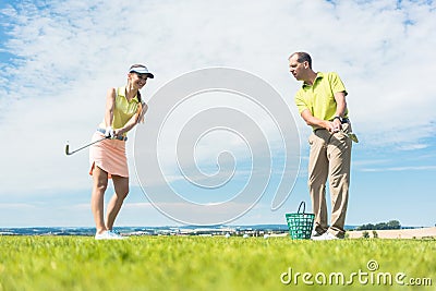 Young woman practicing the correct move during golf class Stock Photo