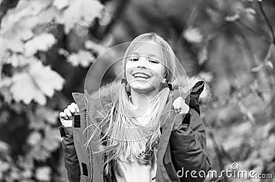 Full of life energy. Kid girl wear coat for autumn season nature background. Child cheerful on fall walk. Warm coat best Stock Photo