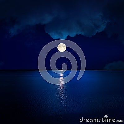 full moon in clouds over water Stock Photo