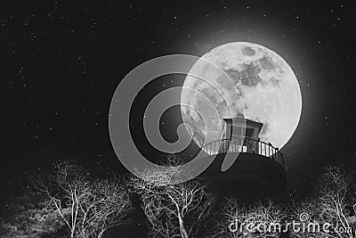 Full moon at night with lighthouse on clear sky with stars, and dead branches, black and white images Stock Photo