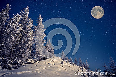 Full moon in the night sky in winter mountains Stock Photo