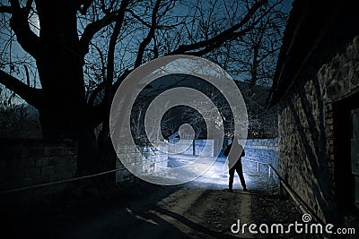 Full moon over quiet village at night. Beautiful night landscape of mountain village under the moonlight. Silhouette of person Stock Photo