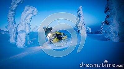 Full moon over snowy mountains as snowmobile carves through Editorial Stock Photo