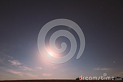 Full Moon Rising Above Field In Countryside. Night View Of Natural Glowing Stars. Car Parked On Field Under Blue Night Stock Photo