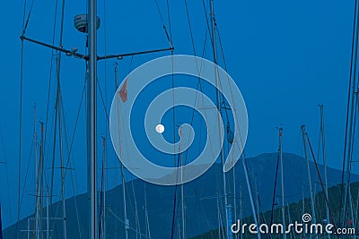 Full moon among sailing boat masts in marina Stock Photo