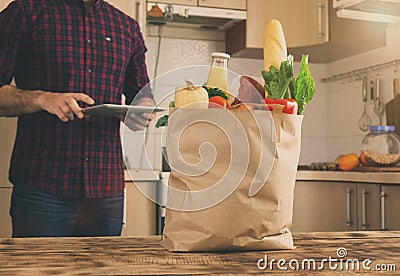 Full paper bag of different food in the home kitchen Stock Photo