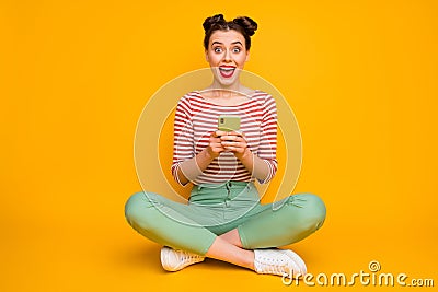 Full size photo of attractive excited lady sit floor legs crossed hold telephone check followers shocked wear striped Stock Photo