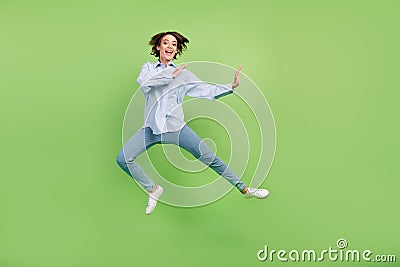 Full size photo of cheerful young nice happy woman jump up fighter amazed excited isolated on green color background Stock Photo