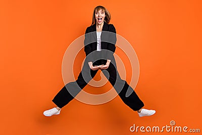 Full size photo of happy crazy smiling good mood positive active energetic girl jumping isolated on orange color Stock Photo