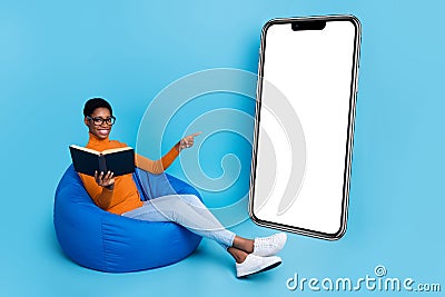 Full size photo of intelligent nonbinary person read book point empty copy space model on blue color background Stock Photo