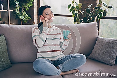 Full size photo of mature woman listen communication say tell speak enjoy cappuccino caffeine sitting divan indoors Stock Photo