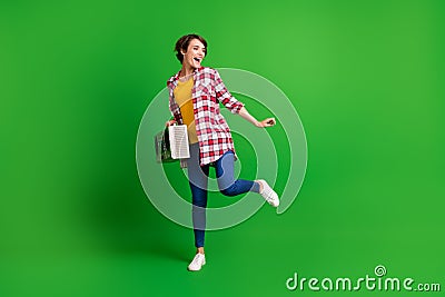 Full size photo of nice funky lady dancing hold boombox wear jeans shirt sneakers isolated on green background Stock Photo
