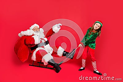 Full size photo of santa claus rider in eyewear eyeglasses spectacles and small redhair elf hat headwear pull sledges Stock Photo