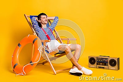 Full size photo of sleepy relaxed young man lie chair nap lifeguard isolated on yellow color background Stock Photo