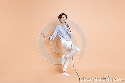 Full size photo of young excited girl enjoy sing pop song microphone concert isolated over beige color background Stock Photo