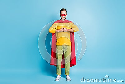 Full size photo of young handsome serious powerful super man in red cape and mask isolated on blue color background Stock Photo