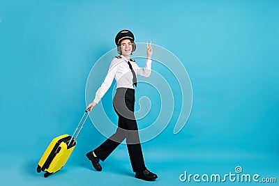 Full size profile photo of optimistic nice brunette hair lady show v-sign go wear pilot uniform isolated on blue Stock Photo