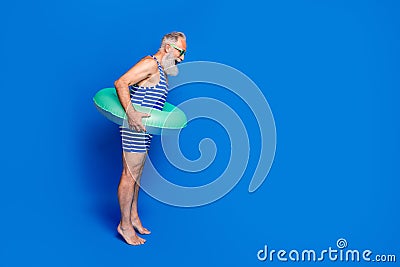Full size profile side photo of shocked amazed old man with buoy prepare to dive isolated on blue color background Stock Photo