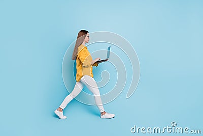 Full size profile side photo of young business woman happy positive smile go walk work laptop isolated over blue color Stock Photo