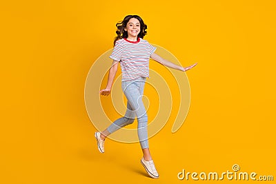 Full size profile side photo of young schoolgirl happy positive smile go walk step jump isolated over yellow color Stock Photo