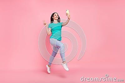 Full size profile side photo of young woman happy smile jump make selfie cellphone show v-sign isolated over pastel Stock Photo