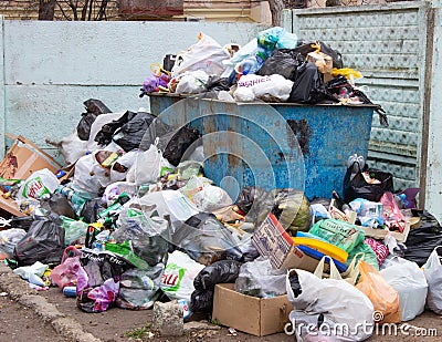 Full trash can. Trash can filled with trash. Trash can packed to overflowing with rubbish. The bin is filled with rubbish Editorial Stock Photo