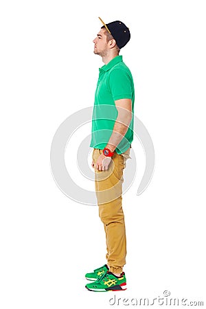 Fullbody profile portrait of young man standing in studio isolated on white. Stock Photo